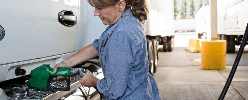 Femme en train de mettre du gaz dans son camion
